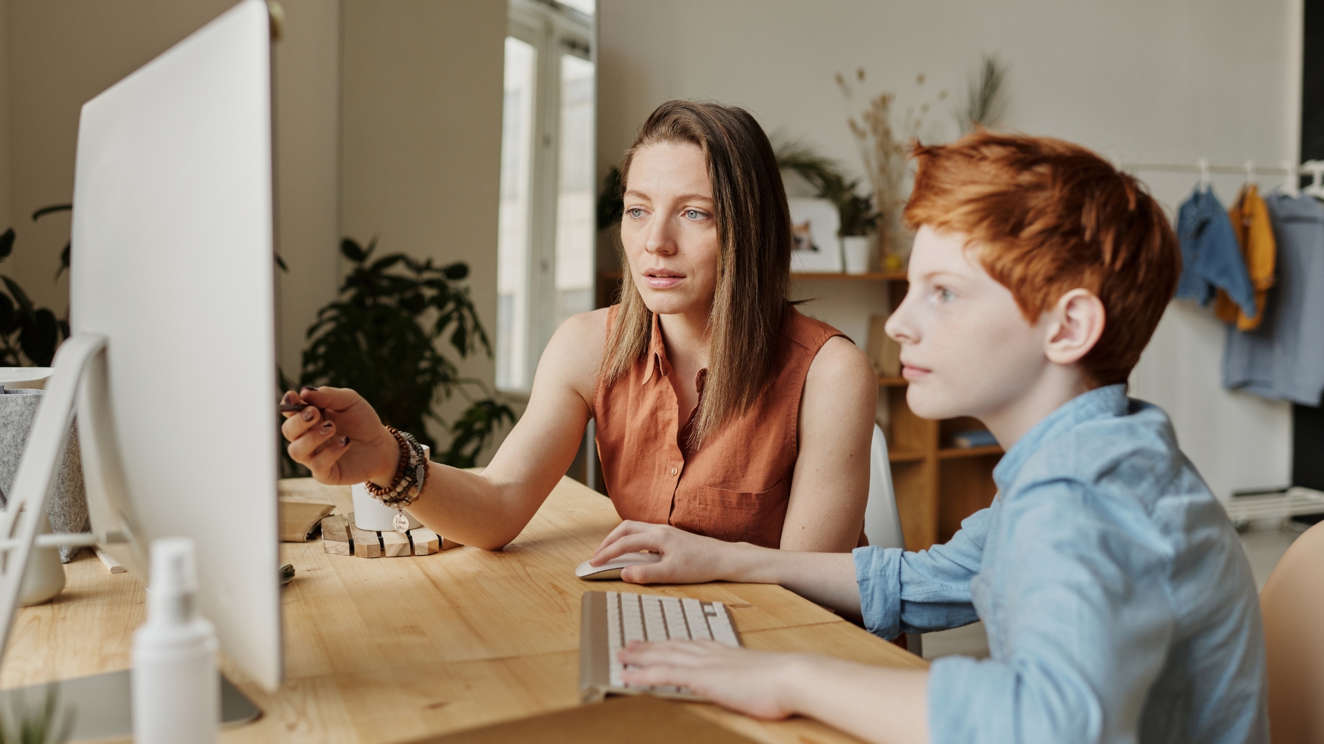 A mother and son picking an online tutor on the computer